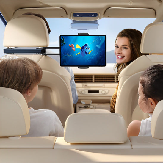 Deux enfants partagent une tablette fixée au support tablette voiture en pleine route.
