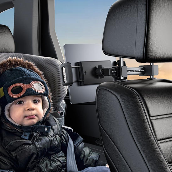 Enfant assis confortablement regardant un dessin animé grâce au support tablette voiture rotatif.
